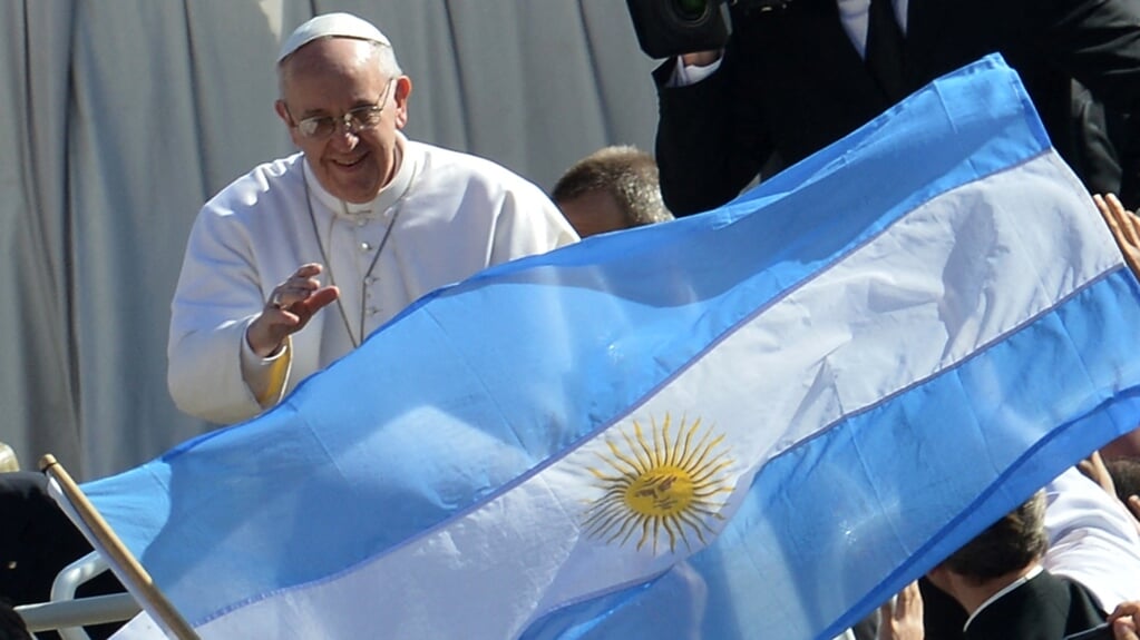 Paus Franciscus zwaait naar mede-Argentijnen met hun vlag op het Sint-Pietersplein vlak na zijn verkiezing als paus in maar 2013. Hij heeft sindsdien geen voet meer op Argentijnse bodem gezet. 