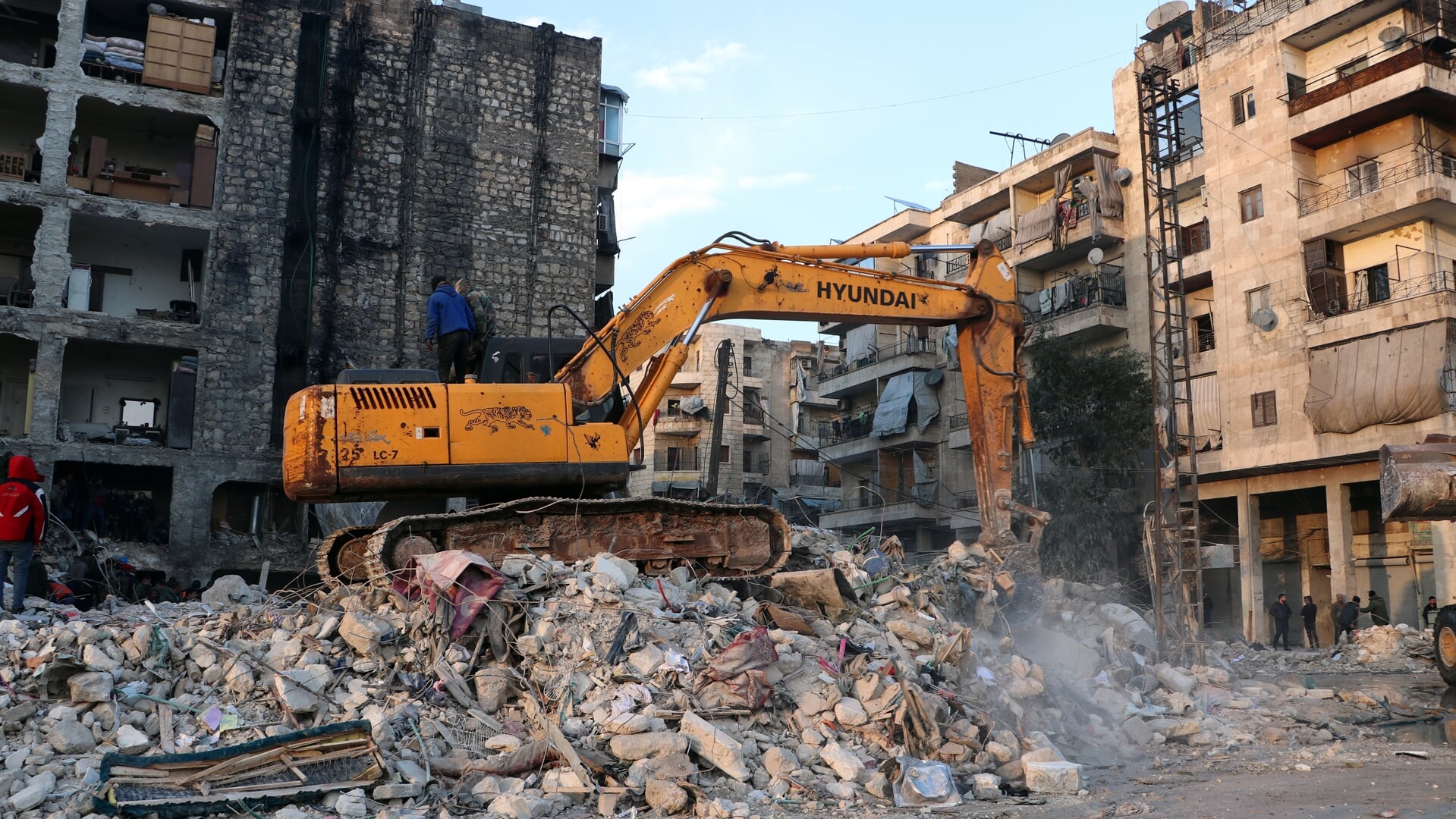 Reddingsoperaties in het puin van een ingestort huis in een wijk in Aleppo.