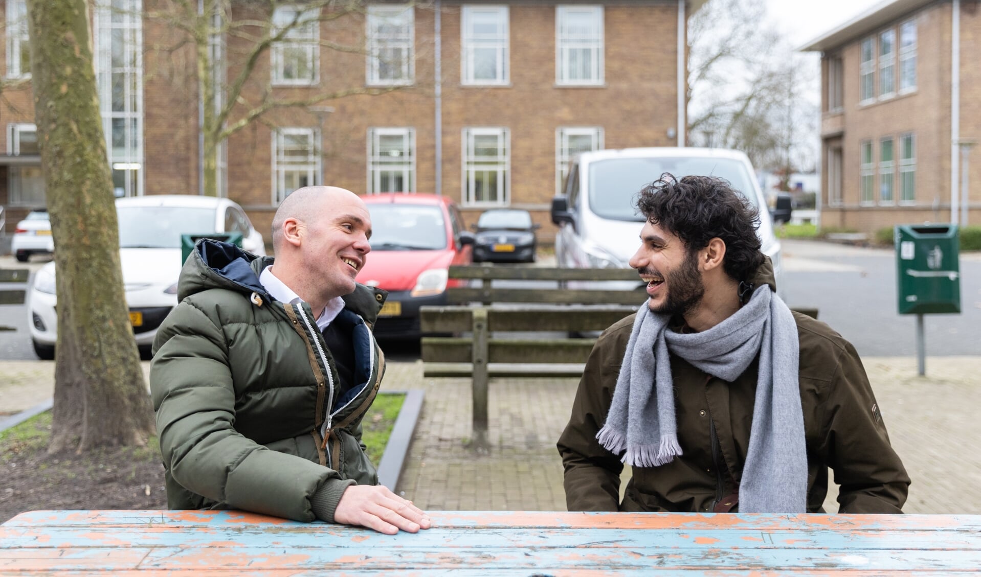 Raphaël Nouwen (links) in gesprek met een vluchteling (die niet met zijn naam in de krant wil) bij het azc in Utrecht.