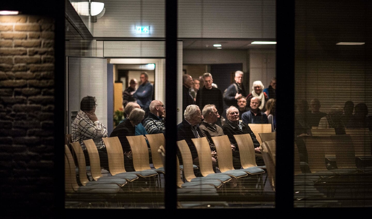 Apeldoorn, dinsdagavond. Mensen bespreken hun zorgen over de koers van de Geformeerde Kerken vrijgemaakt.