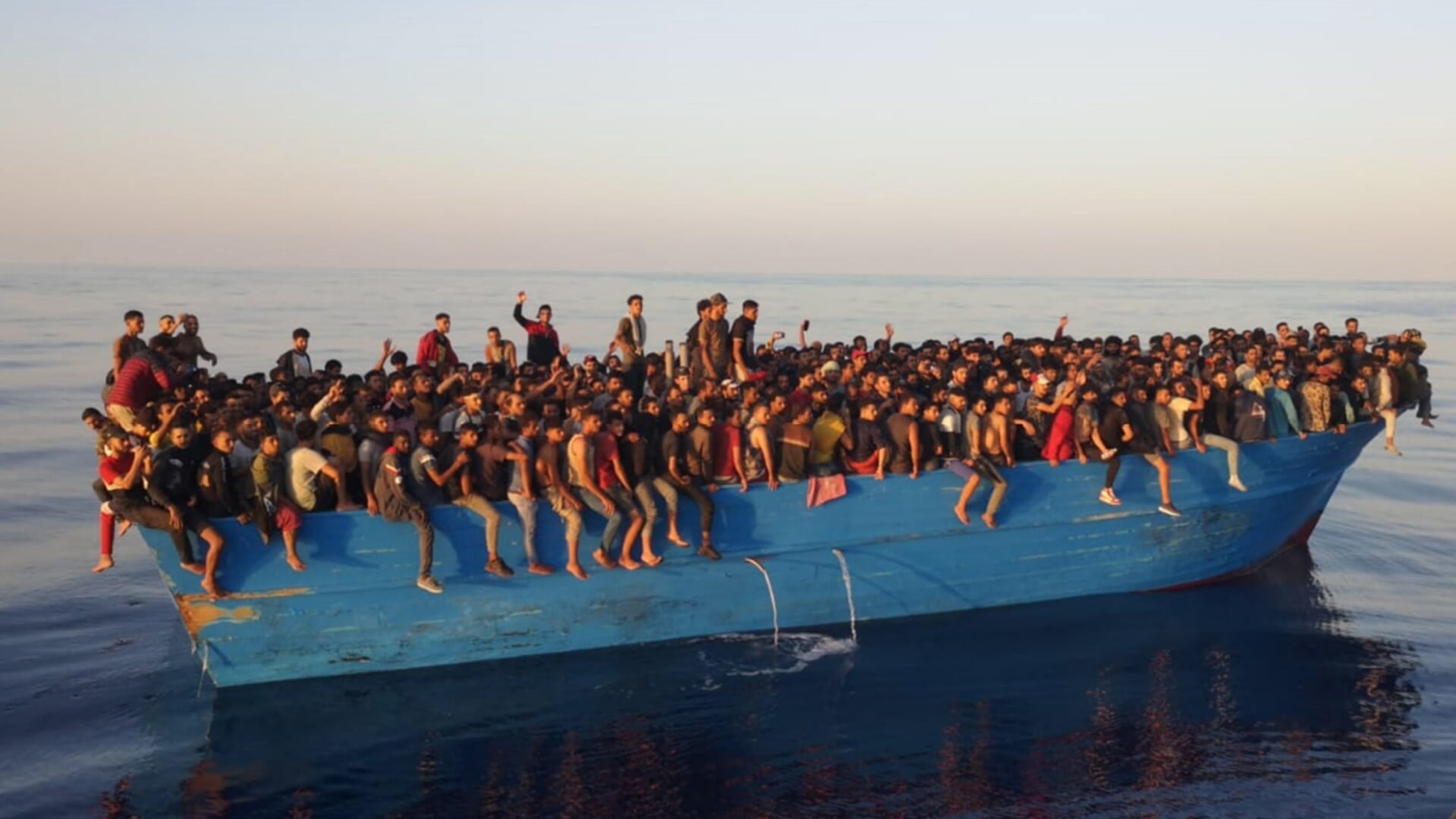 Vierhonderd migranten op een volgepakte boot voor het Italiaanse eiland Lampedusa.