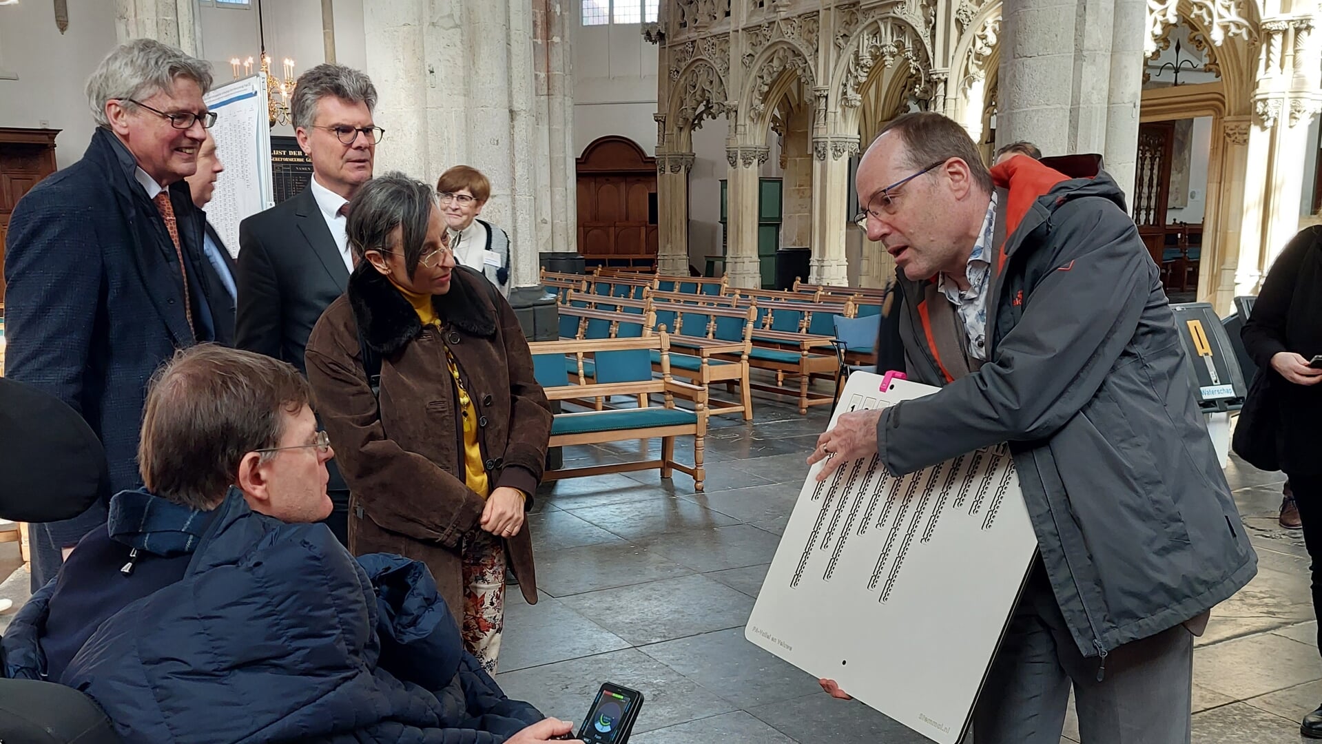 Projectleider Bert Kuijer toont het braillebord aan de ambassadeur van Italië en zijn vrouw. Achter hen de burgemeester van Amersfoort en de commissaris van de Koning in Utrecht.