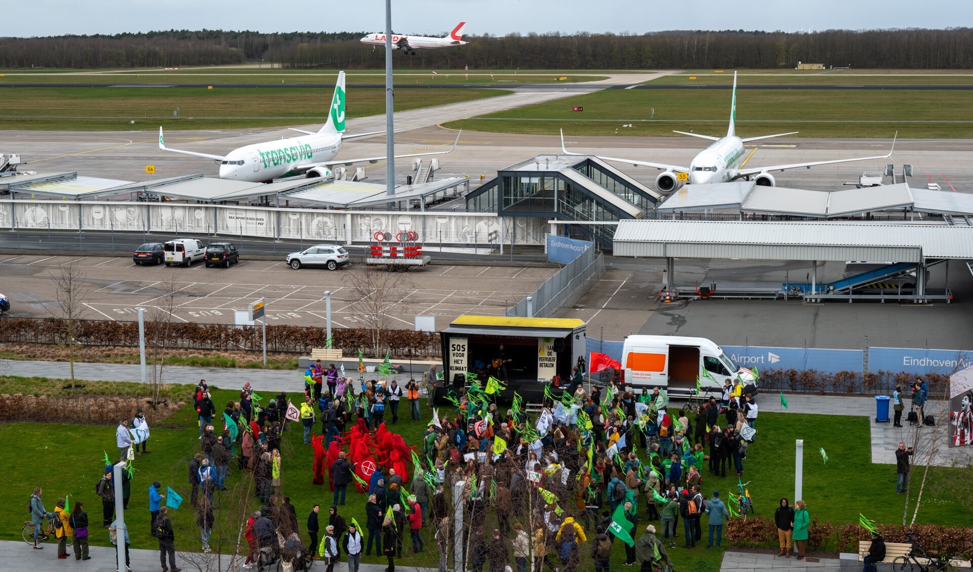 Sympathisanten van Extinction Rebellion betuigen hun steun op het voorplein van vliegveld Eindhoven, terwijl de actiegroep zich richtte op het terrein voor privévliegtuigen.