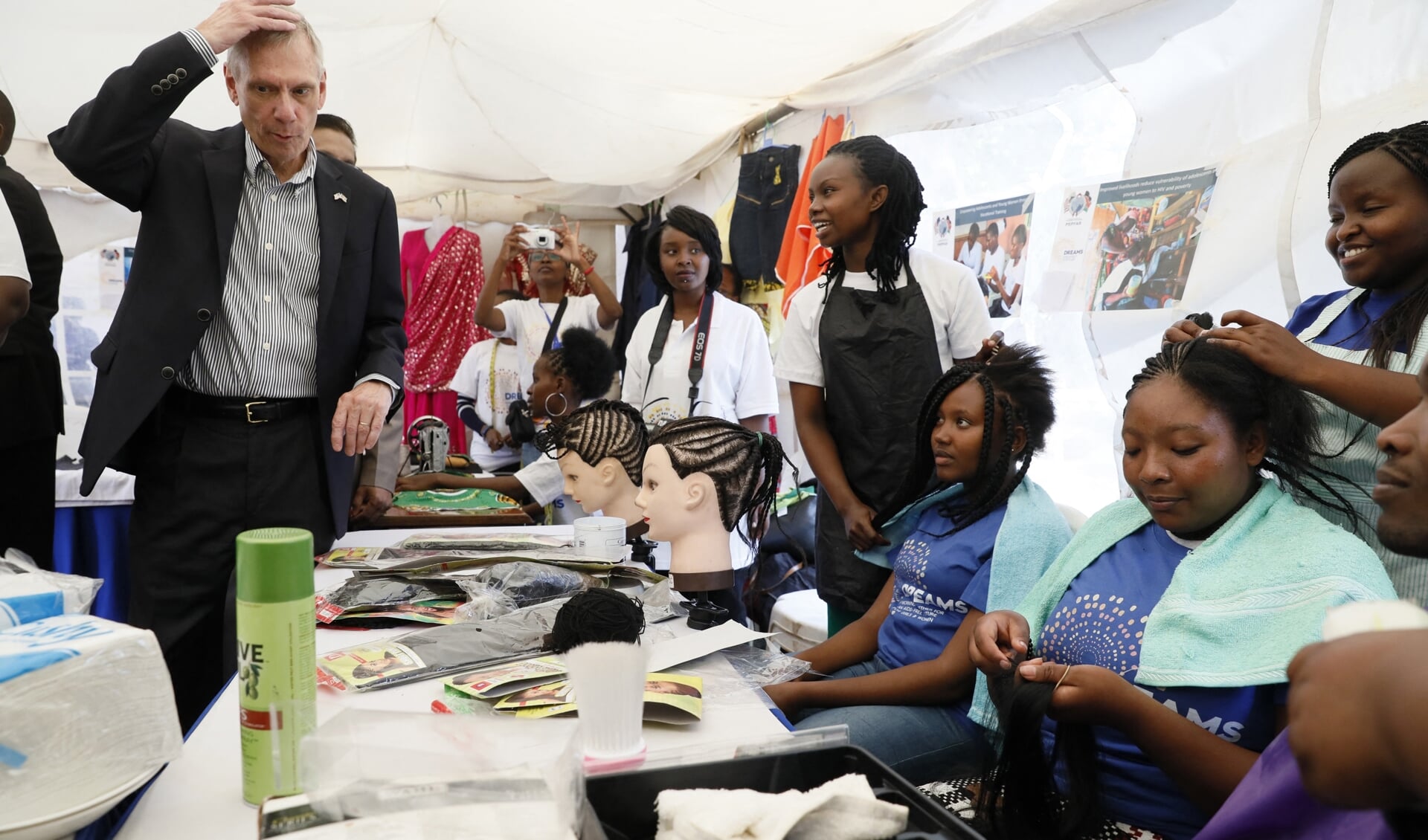 Een van de onderdelen van Pepfar is het versterken van de positie van meisjes en vrouwen, zoals in dit project in Nairobi, Kenia waar de Amerikaanse ambassadeur Robert Godec op bezoek was.