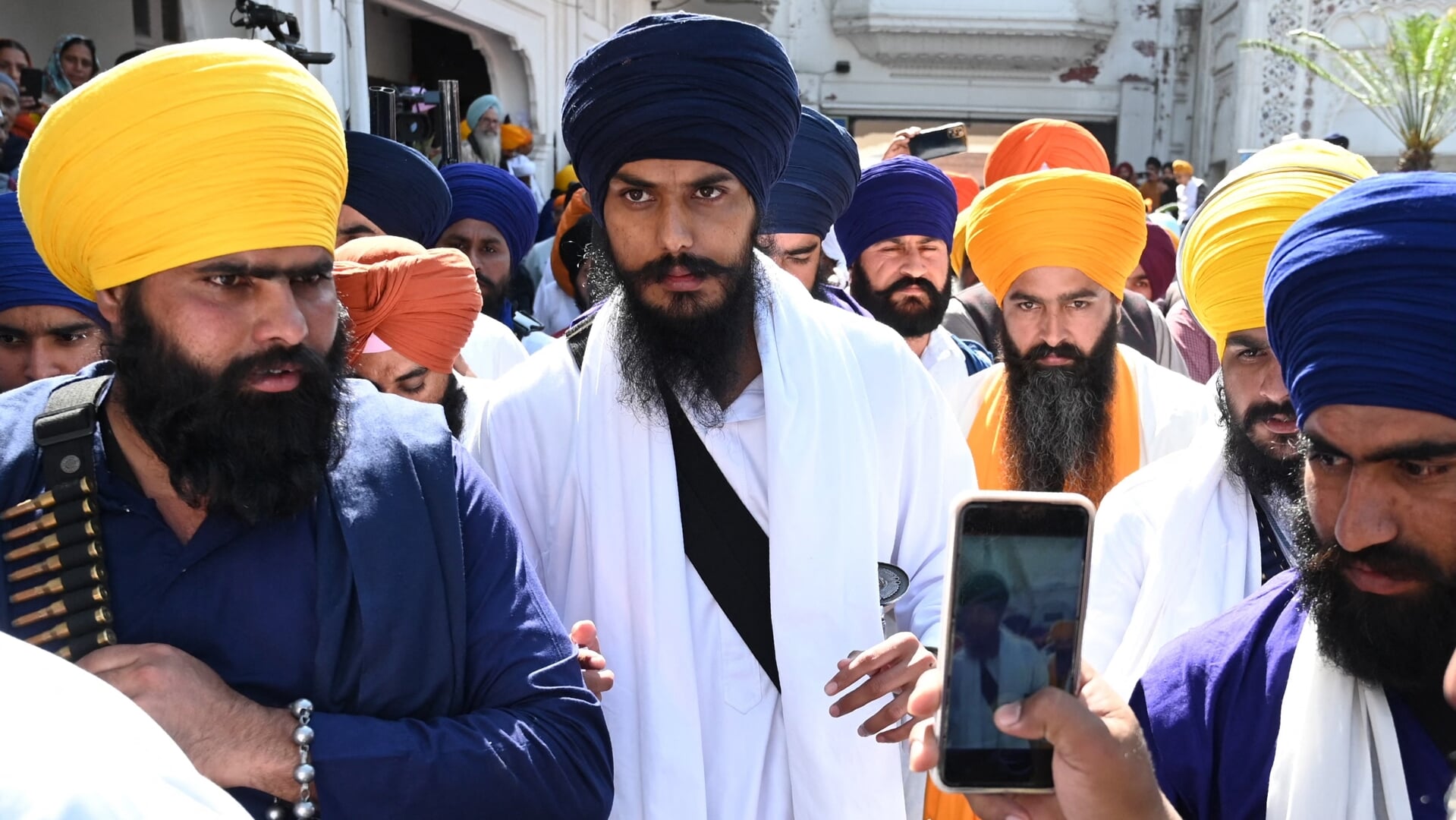 Amritpal Singh Sandhu (midden), hier bij de gouden tempel van Amritsar, is volgens de Indiase regering bezig met de opbouw van een gewapende militie om te strijden voor Khalistan.