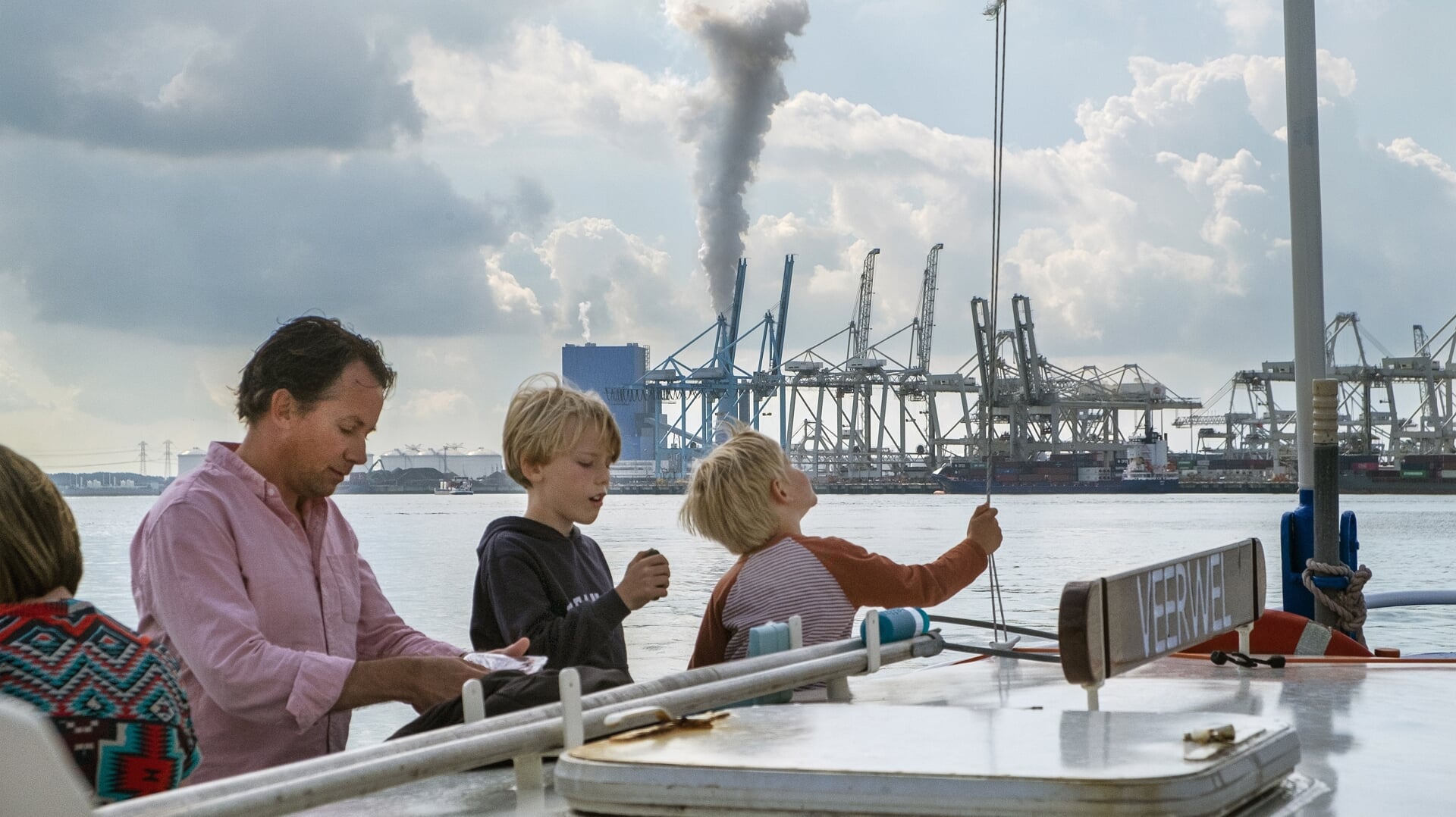 Toeristen varen mee op de pont langs een kolencentrale op de Maasvlakte. Een nieuw klimaatrapport dat maandag verschijnt, moet overheden aanzetten tot actie om de uitstoot van broeikasgassen snel terug te dringen.