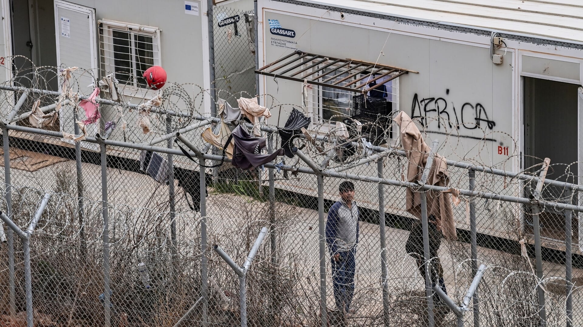 Asielzoekers in een kamp op het Griekse eiland Kos. De afgelopen jaren worden vluchtelingenkampen op de Griekse eilanden in toenemende mate afgesloten van de buitenwereld.
