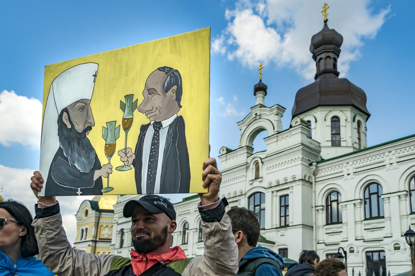 Een cartoon van Kirill en Poetin, op Witte Donderdag bij het Petsdjersk Lavra klooster in de Oekraïense hoofdstad Kyiv.