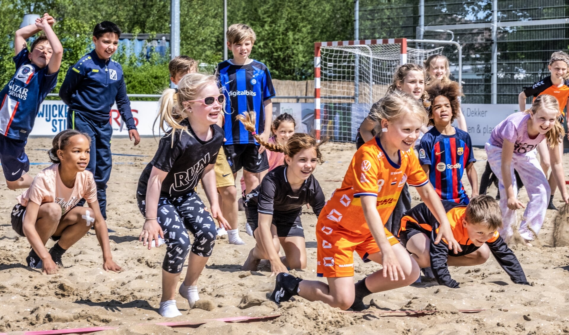 Kinderen aan het sporten op een sportcomplex in Heemstede waar een beach-ondergrond is neergelegd.