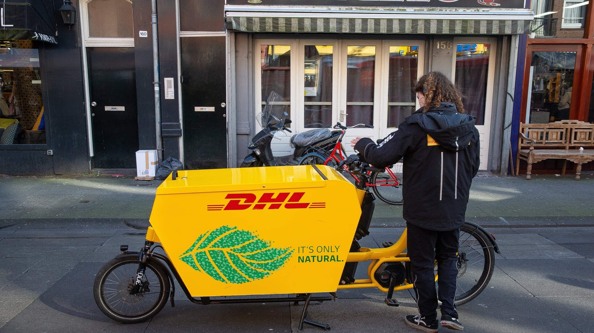 DHL-bezorger levert pakketten af per fiets.