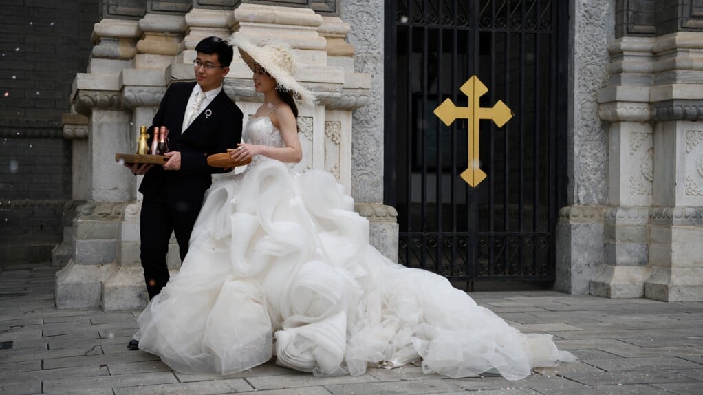 Een echtpaar maakt trouwfoto's voor de rooms-katholieke Sint-Jozefkerk in Peking (China). Het christelijk denken over het huwelijk is vanaf de elfde eeuw sterk veranderd.
