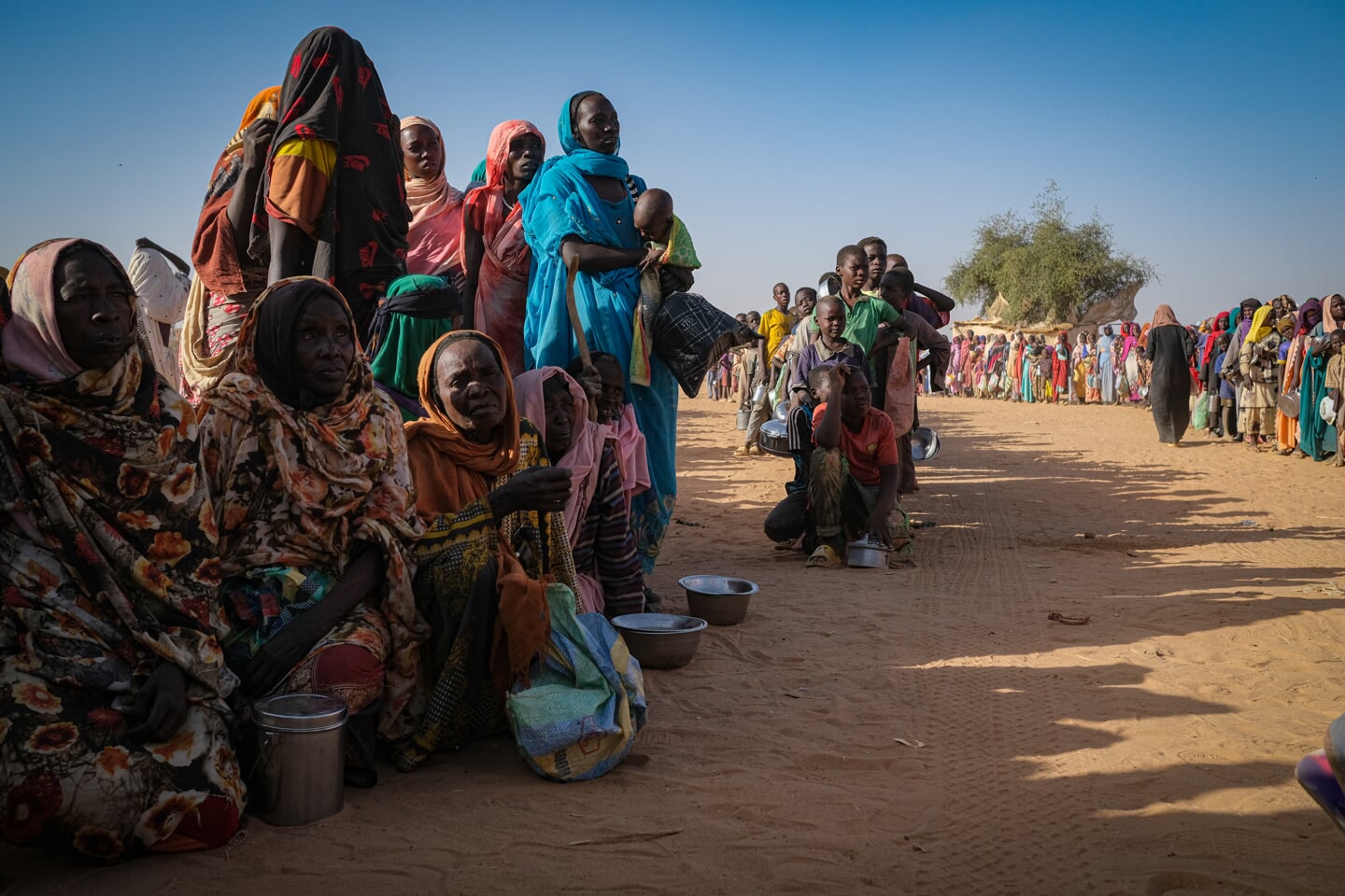 Soedanese vluchtelingen in grensstad Adré in de rij voor eten van een hulporganisatie.