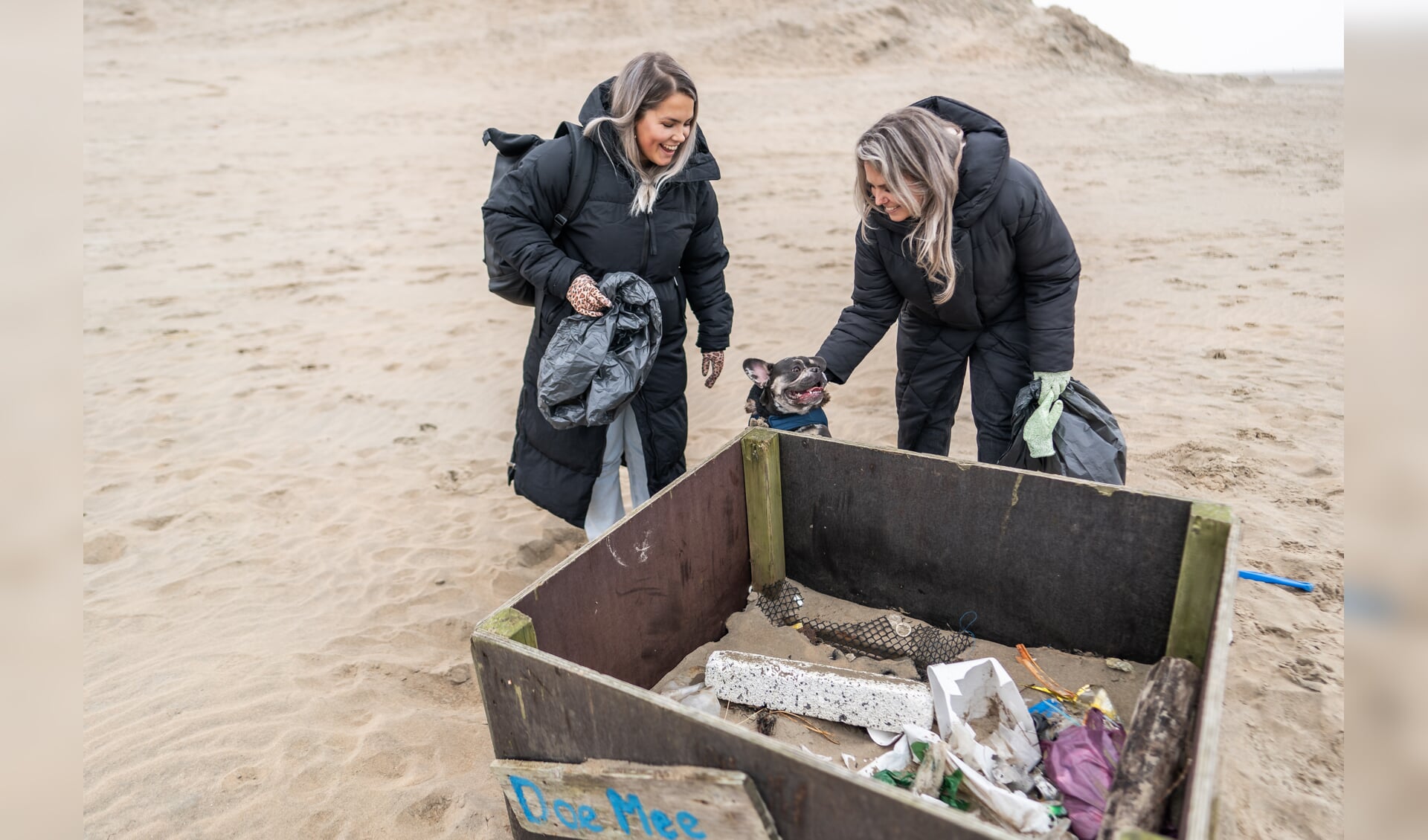 Raisa Mooseker (groene handschoenen) en haar zus Gaya Mooseker doen in gezelschap van hond Beppie mee aan het project ‘Meet mee voor een schone Noordzee’.