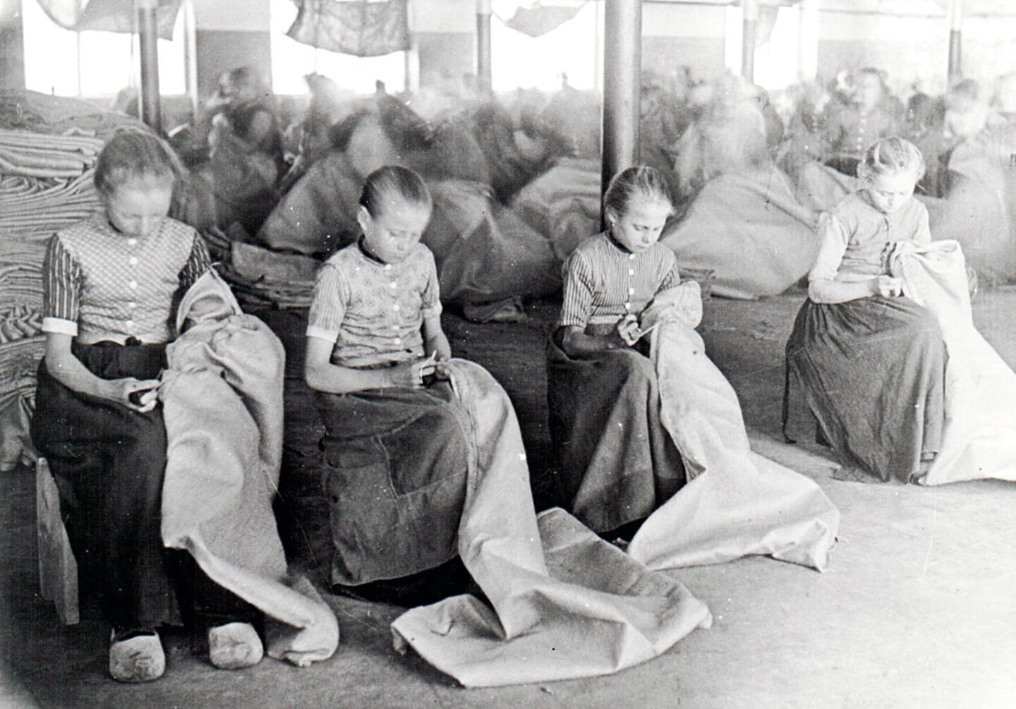 Kinderen naaien jute zakken. Kinderarbeid in fabrieken was een van de kwalijke gevolgen van de snelle modernisering van Nederland in de negentiende eeuw.
