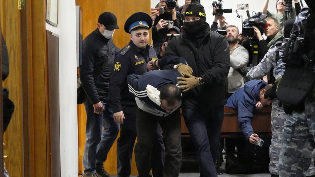 Een van de verdachten van het bloedbad in de Crocus City Hall in Moskou wordt de rechtszaal in gebracht.