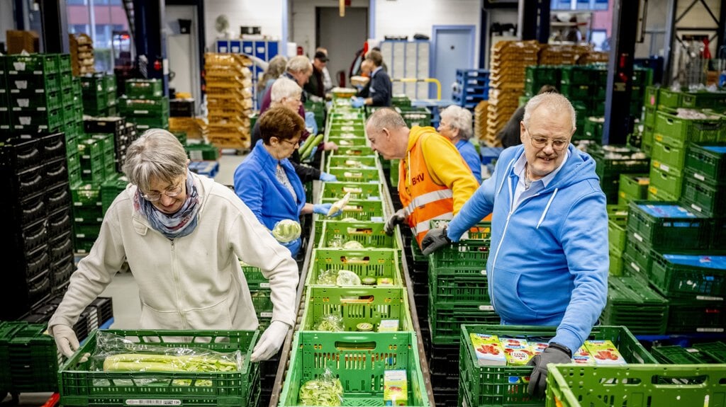 Vrijwilligers van de Voedselbank in Den Haag zijn voedselpaketten aan het inpakken. In 2023 deden vrijwilligers vaker incidenteel (af en toe of eenmalig) vrijwilligerswerk dan in 2022.  