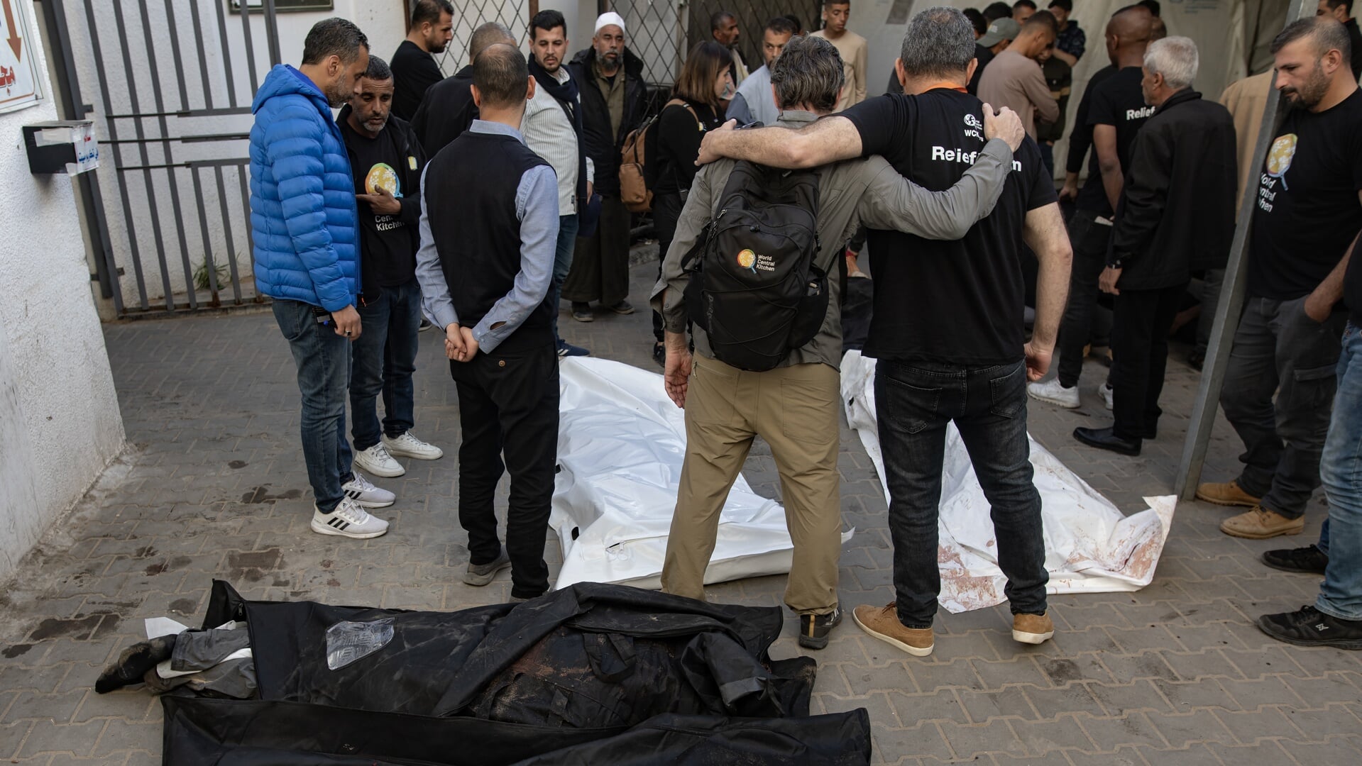 Medewerkers van World Central Kitchen treuren bij de lichamen van hun collega's die maandag om het leven kwamen bij een Israëlische aanval.