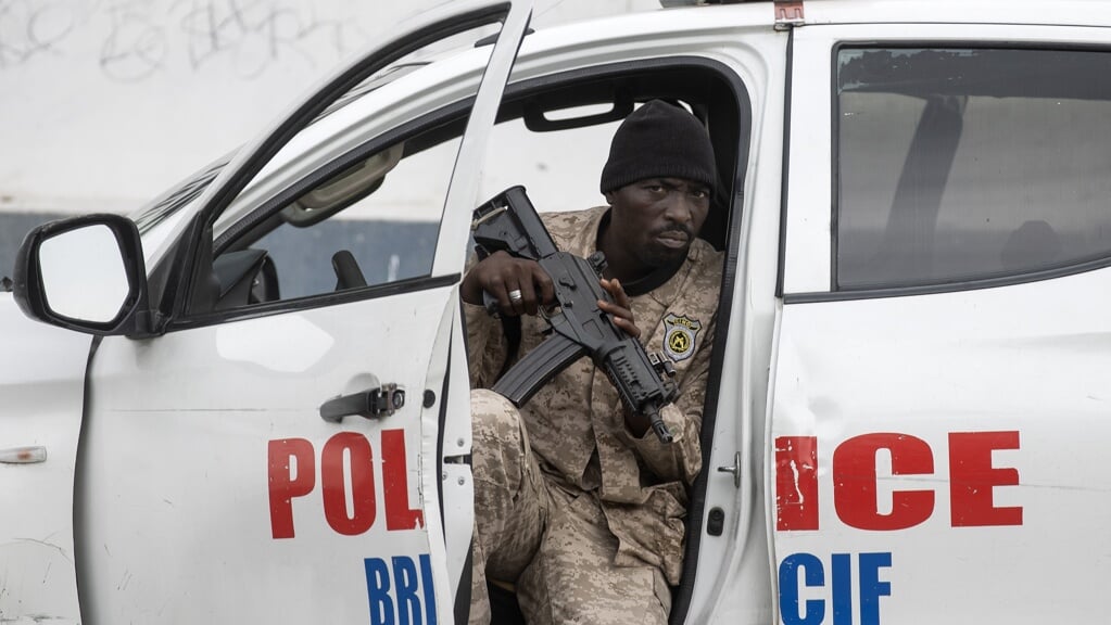 Een politieagent houdt de wacht vanuit een politievoertuig in de Haïtiaanse hoofdstad Port-au-Prince.