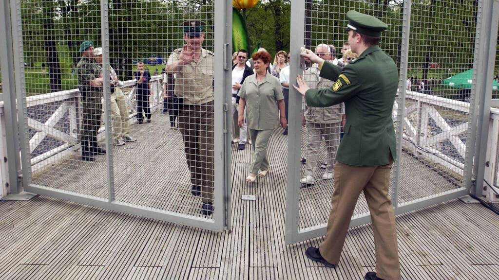 1 mei 2004: een Duitse (rechts) en een Poolse grenswacht openen de grens tussen de landen op de brug in Bad Muskau.