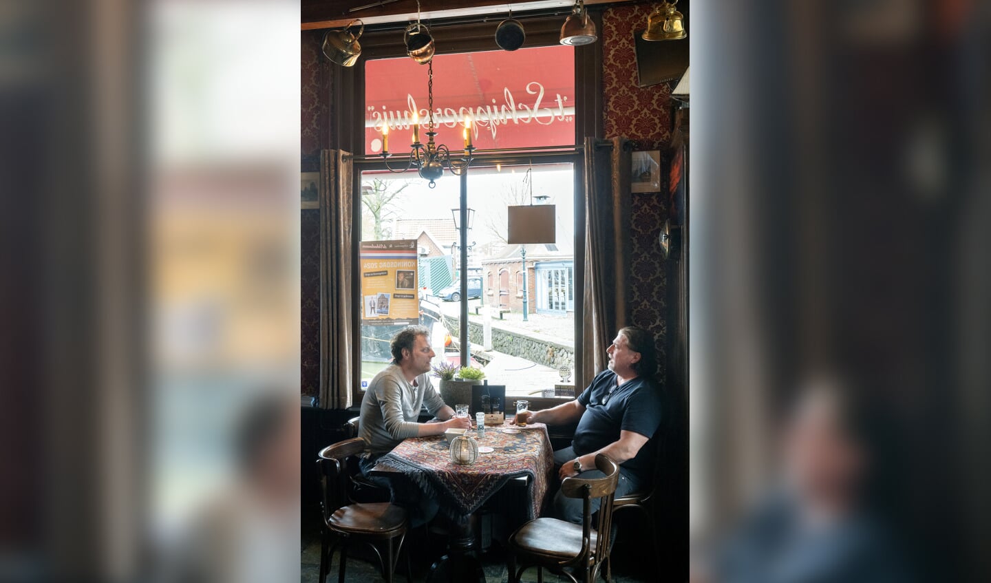 Edwin Meerman (links) en eigenaar Herk van Hoof in het bruine café waar Pierre Kartner zijn bekende liedje over schreef. 'Natuurlijk zijn er toeristen die even willen kijken, maar mijn gasten zijn vooral van hier. '