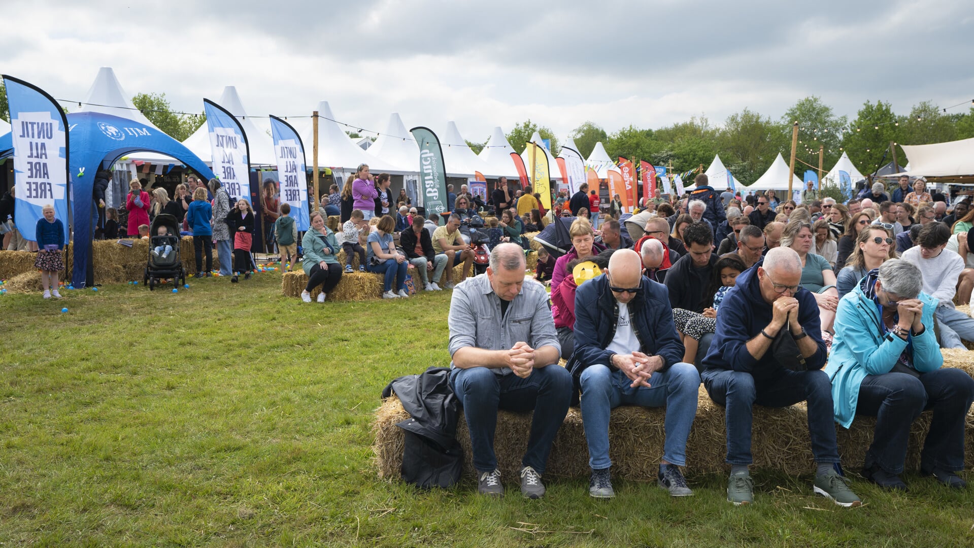 Bezoekers nemen buiten plaats, want de grote tent is vol op de eerste dag van het Strandheem Festival. 