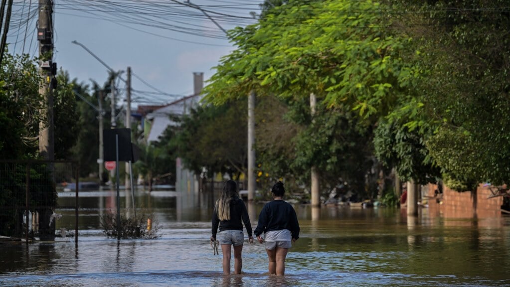 Twee mensen lopen door overstroomd gebied in Eldorado do Sul, in de Braziliaanse deelstaat Rio Grande do Sul.