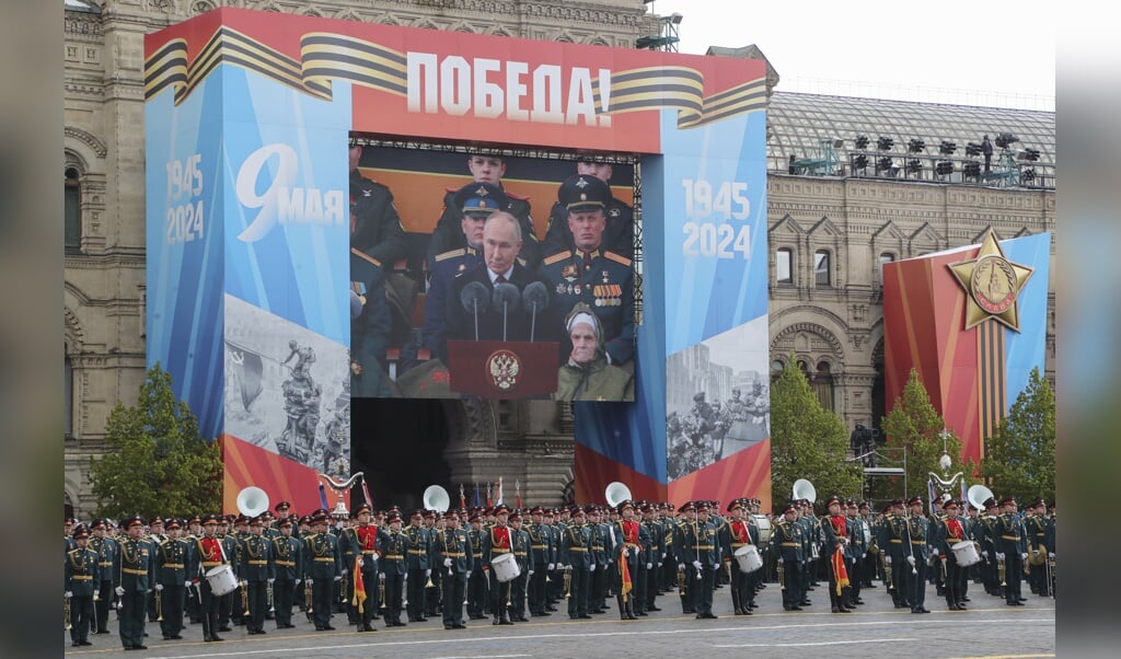 Via een groot scherm is de jaarlijkse toespraak van president Vladimir Poetin op het Rode Plein in Rusland te volgen. 