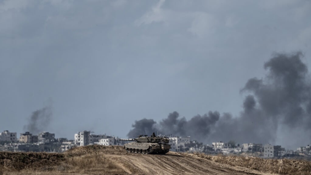 Rook stijgt maandag op boven Gaza-Stad. Op de voorgrond is een Israëlische gepantserd voertuig te zien.