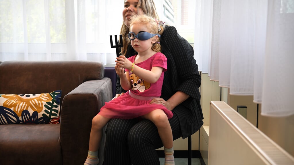 De vierjarige Ava met haar moeder tijdens de oogtest – ‘het oogspelletje’.