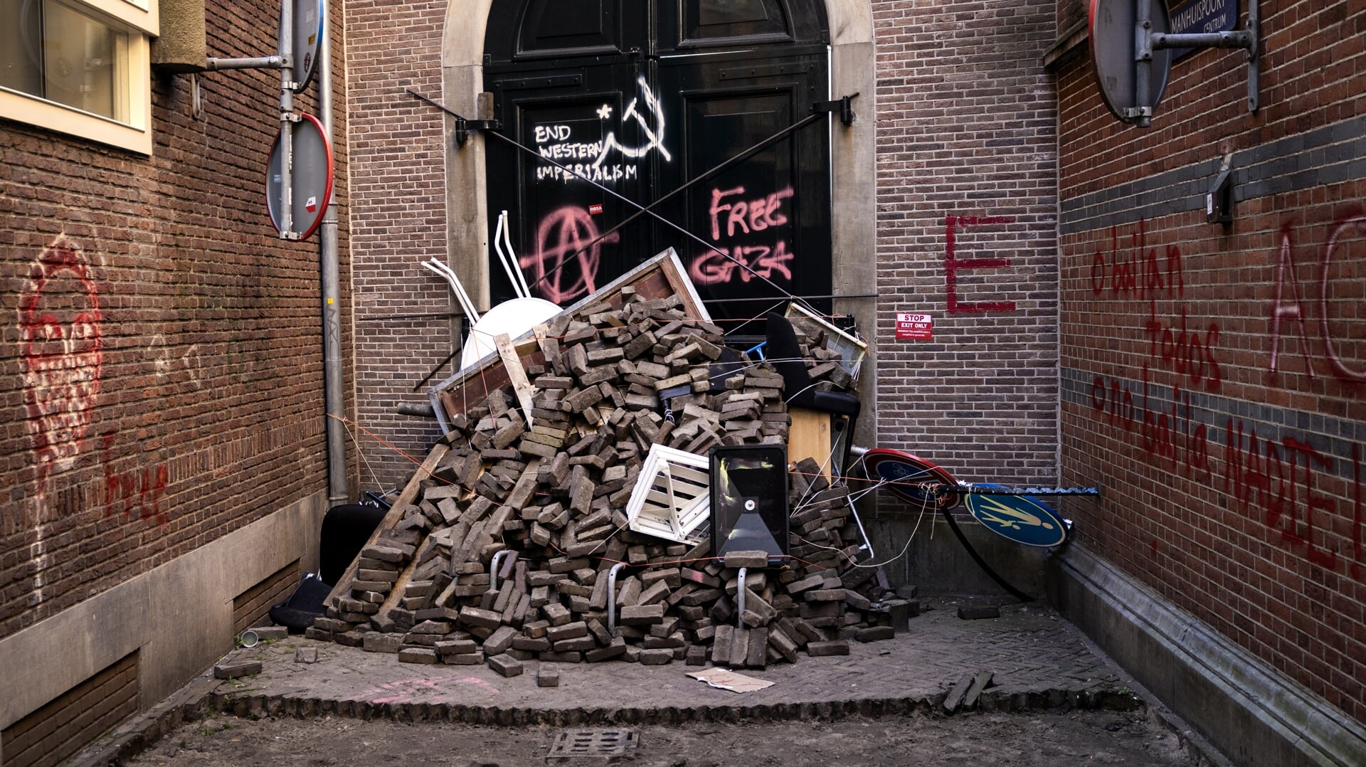 Losse straatstenen en graffiti op gevels zijn de stille getuigen van de UvA-studentenprotesten in Amsterdam.