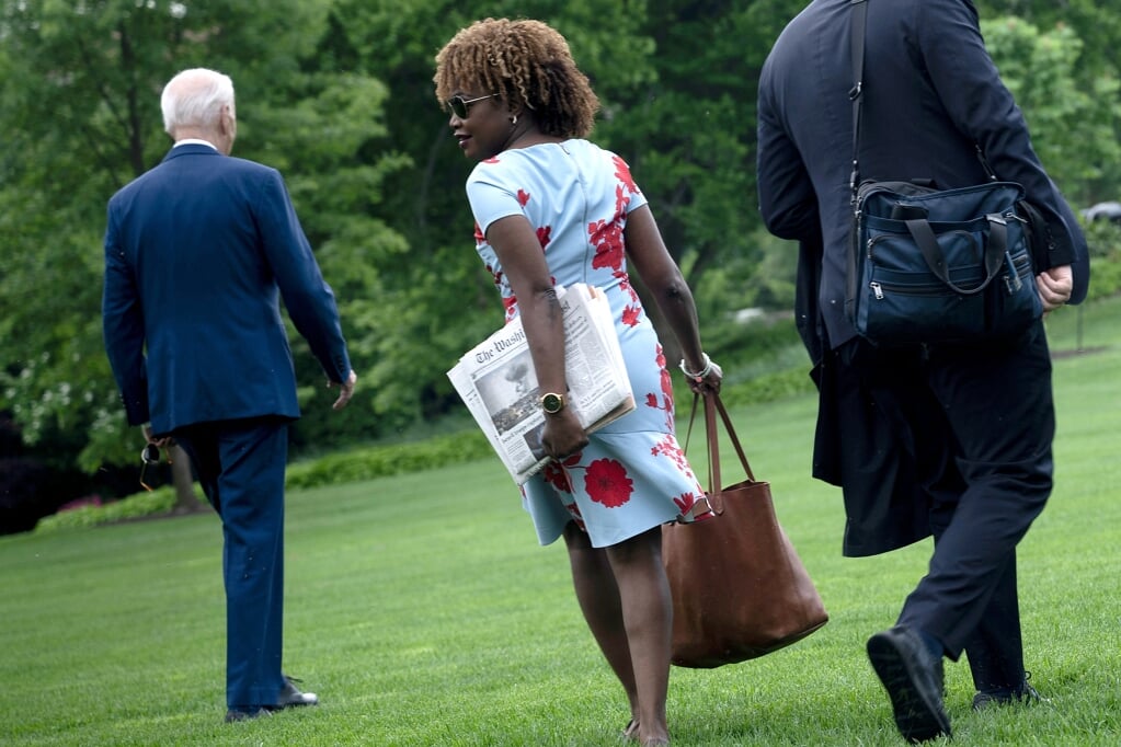 De Amerikaanse president Joe Biden loopt met zijn woordvoerder Karine Jean-Pierre door de tuin van het Witte Huis. In haar hand houdt Jean-Pierre een editie van The Washington Post met een foto van Rafah op de voorpagina.