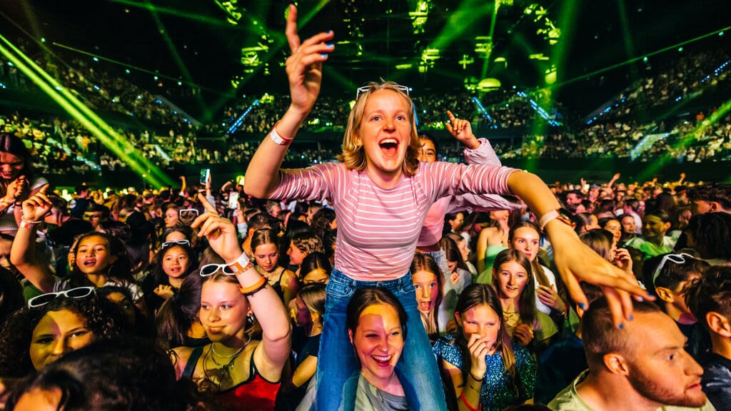 Jongeren drommen dicht samen rondom het podium voor de muziek. 'Je weet dat iedereen hetzelfde gelooft.'