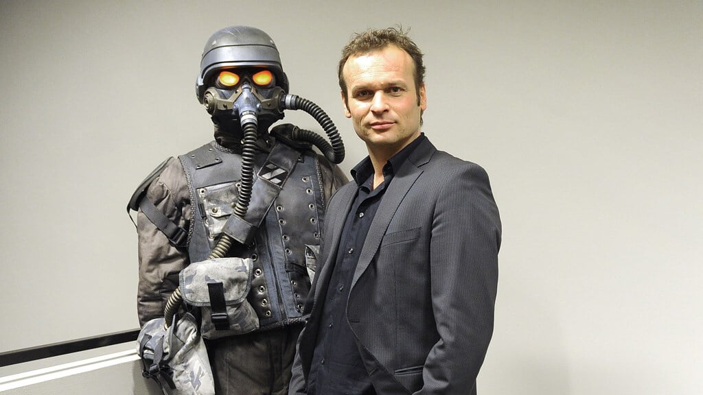 Hermen Hulst poseert naast de hoofdpersoon uit Killzone 3. Hij wordt ceo van Sony Interactive Entertainment, de maker van PlayStation.