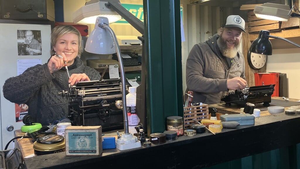Typemachinefabriekeigenaar Rianne Meehan en haar zwager George in hun werkplaats.