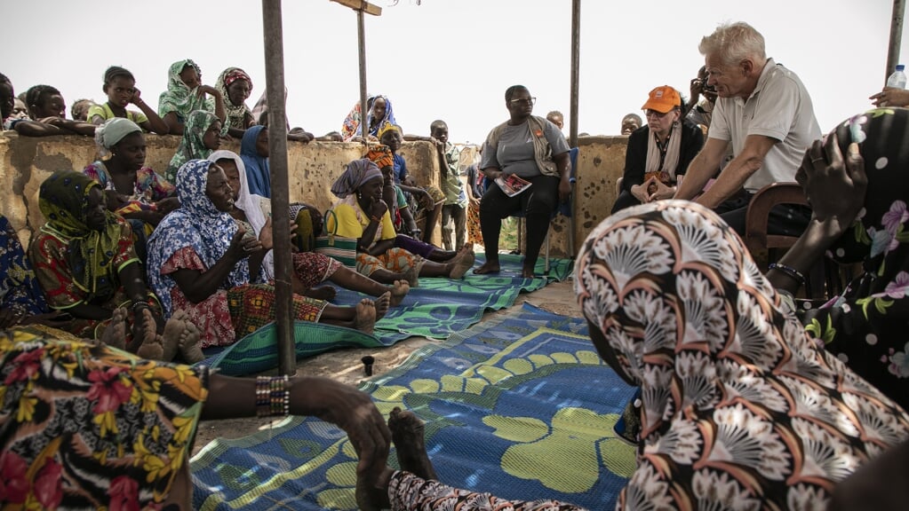 Jan Egeland (r.) praat met een groep ontheemde vrouwen in het ontheemdenkamp Torodi in Dori. Burkina Faso wordt geteisterd door geweld maar er is nauwelijks aandacht voor vanuit de rest van de wereld.