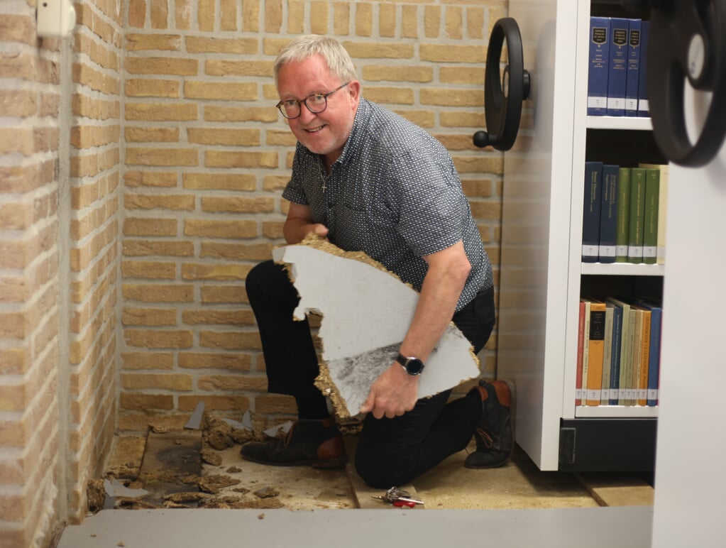 Beheerder Melle Rozema bij de opengewerkte vloer van de bieb van universiteit. 'Mogelijk is de hele ondervloer beschadigd.'