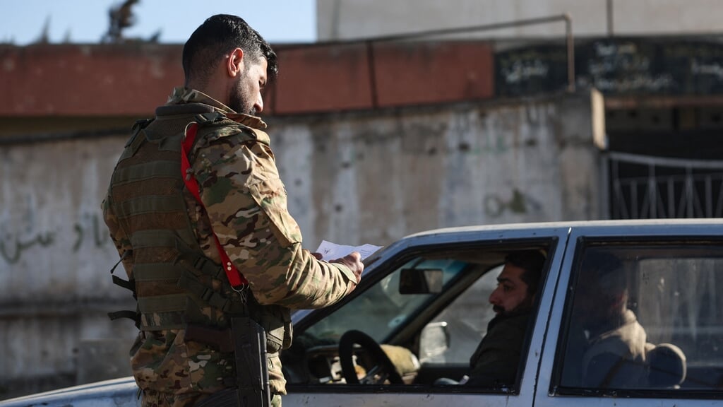 Een automobilist in Homs wordt gecontroleerd door veiligheidstroepen in Homs, eind februari.
