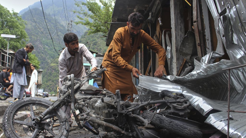 Inwoners van Pakistaans Kasjmir bij een winkel die uitbrandde na een aanval van India.