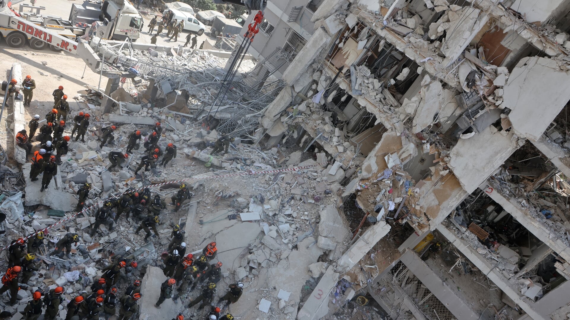 Reddingswerkers bij een zwaar beschadigd gebouw na een Iraanse raketaanval in Bat Yam, vlak bij Tel Aviv.