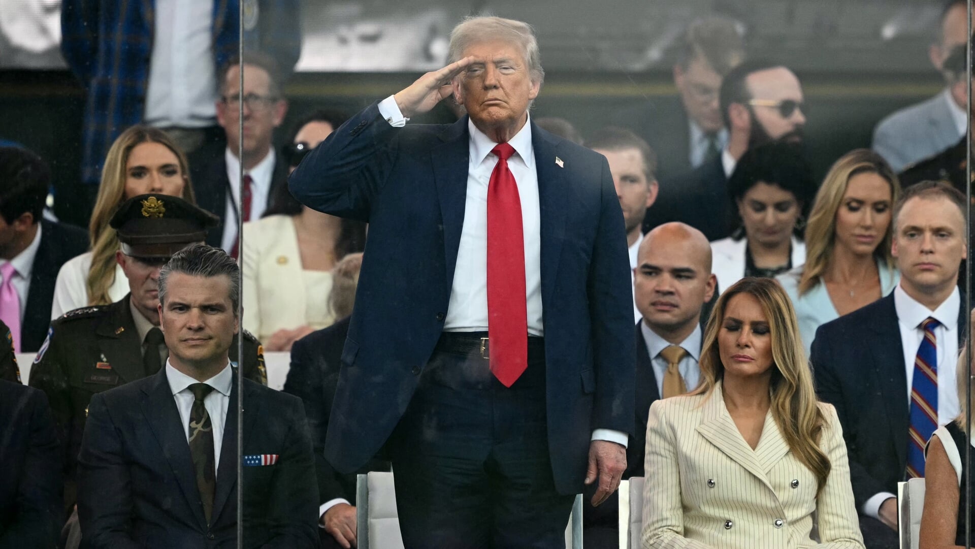 President Trump, geflankeerd door zijn vrouw Melania en Defensieminister Hegseth, salueert tijdens de militaire parade in Washington D.C. afgelopen zaterdag. De parade viel samen met Trumps verjaardag