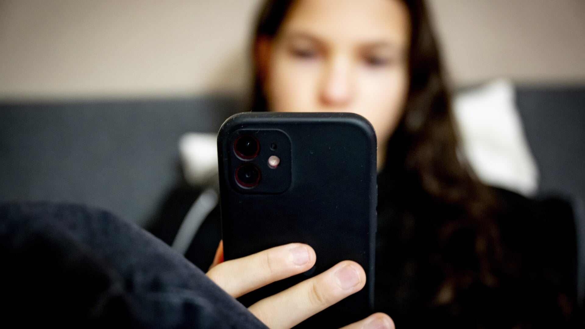 Een meisje op haar telefoon bekijkt de app TikTok.