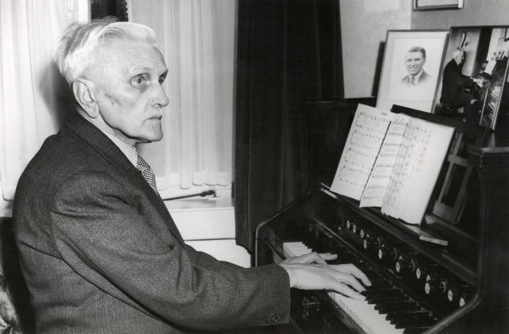 Johannes de Heer (85) in 1951 achter het harmonium met daarop zijn Liedbundel.