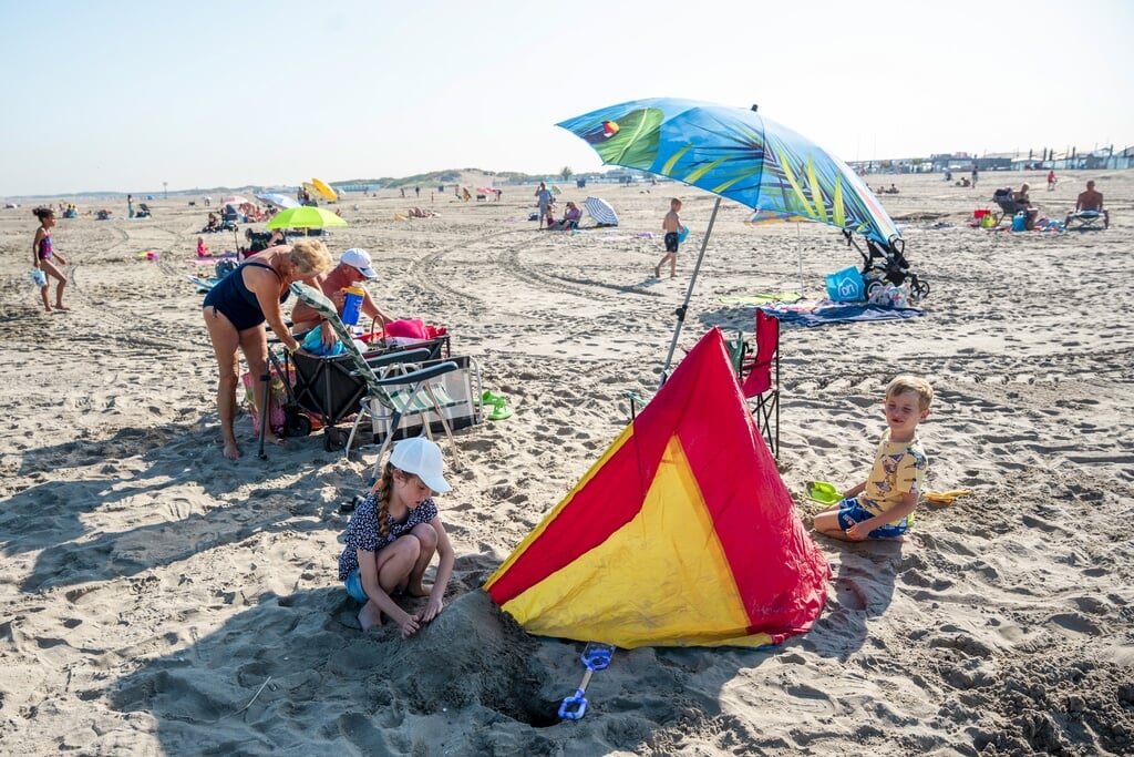 Badgasten op het strand van Hoek van Holland tijdens een zomerse dag in de meivakantie.
