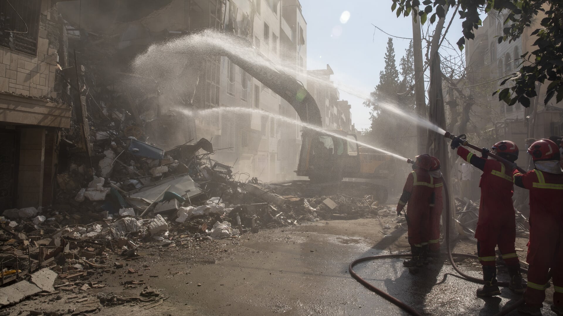 Brandweerlieden staan op 13 juni te blussen bij een gebouw in Teheran dat werd geraakt bij de eerste Israëlische aanvallen.