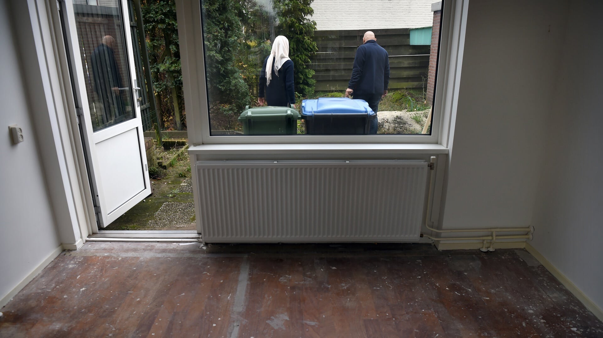 Twee statushouders in de tuin van de woning die ze toegewezen hebben gekregen in Nijmegen.