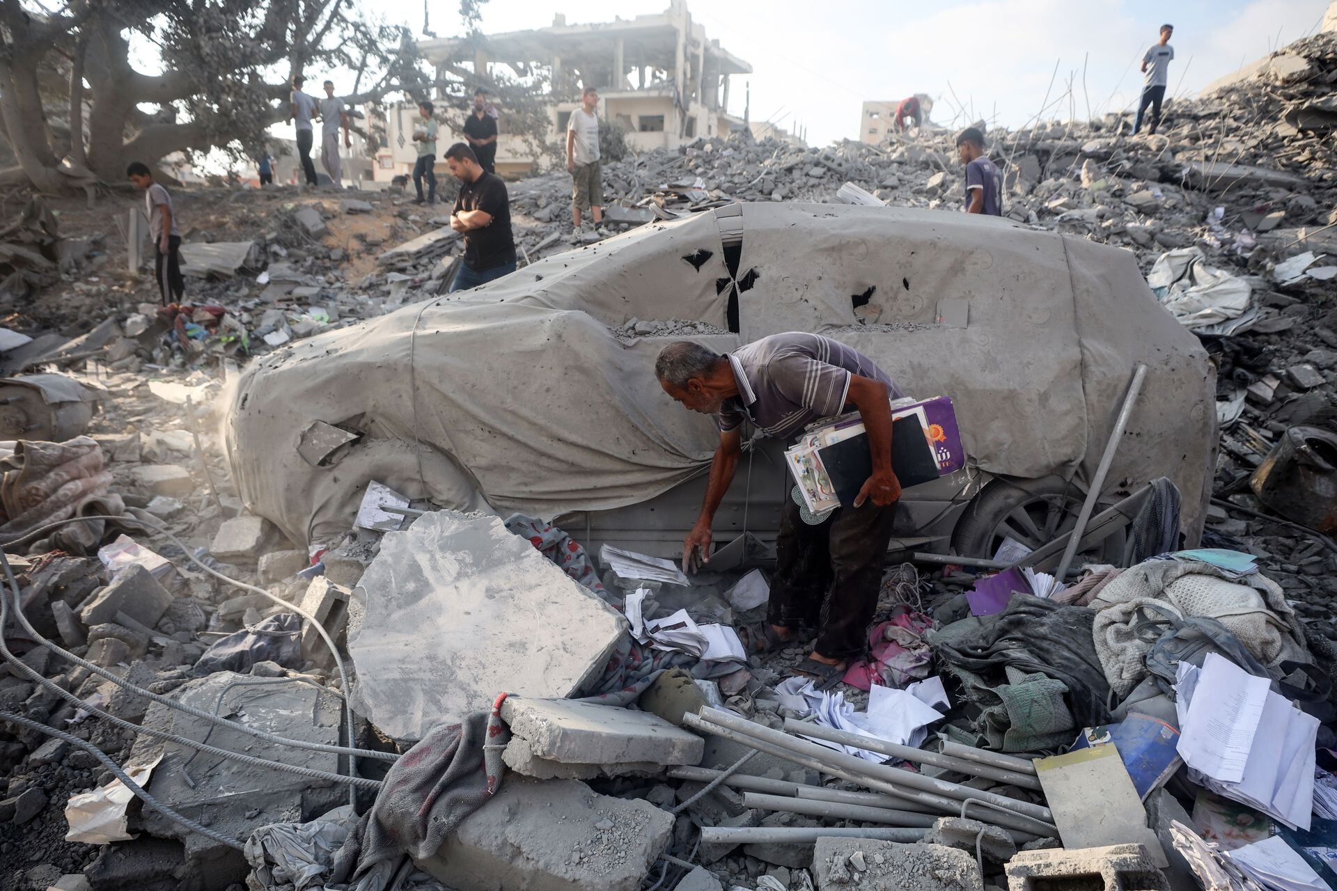 Een Palestijnse man zoekt naar zijn bezittingen in Gaza, na een bombardement op 15 juli 2025.