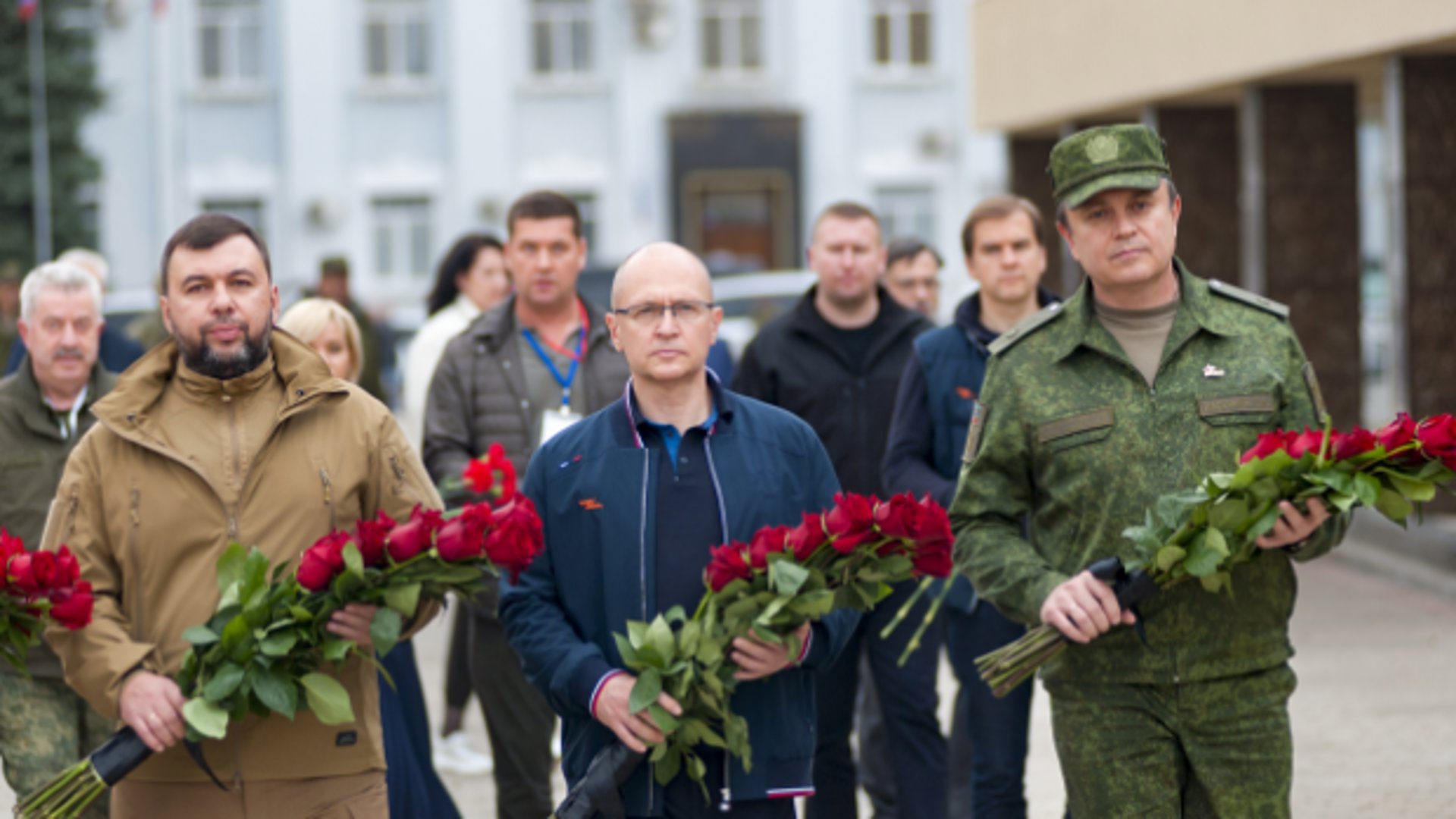 Denis Poesjilin (links), leider van de Volskrepubliek Donetsk legt met Russisch zaakgelastigde Sergei Kirijenko, midden, rozen bij het standbeeld v oor de Jonge Garde 'Onoverwonnen' in Krasnodon, 48 kilometer van Loehansk.