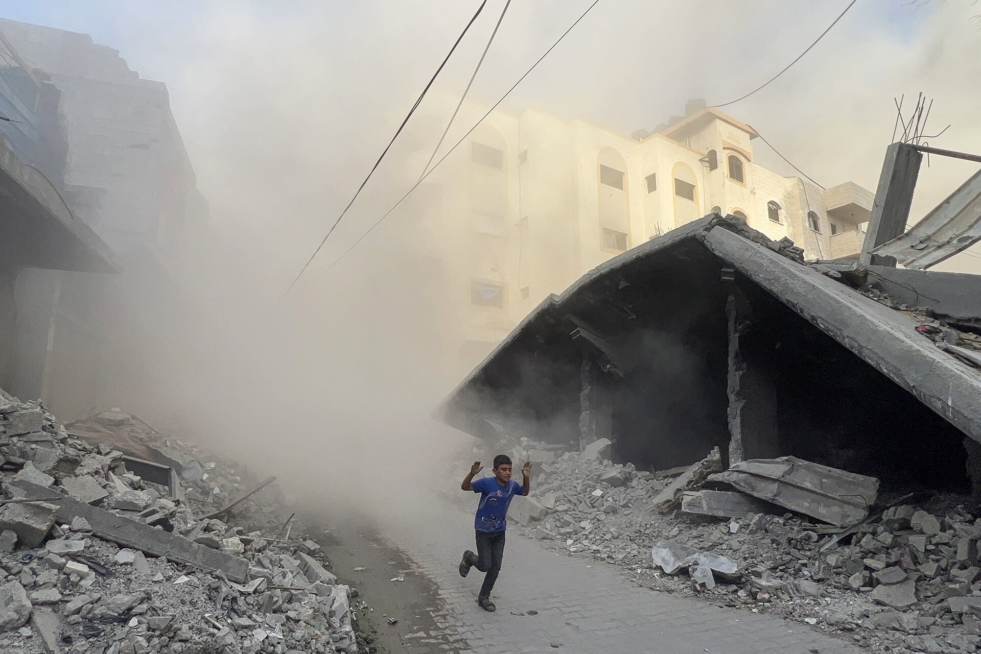 Een Palestijnse jongen rent weg van een gebouw waar een Israëlische raket is ingeslagen.