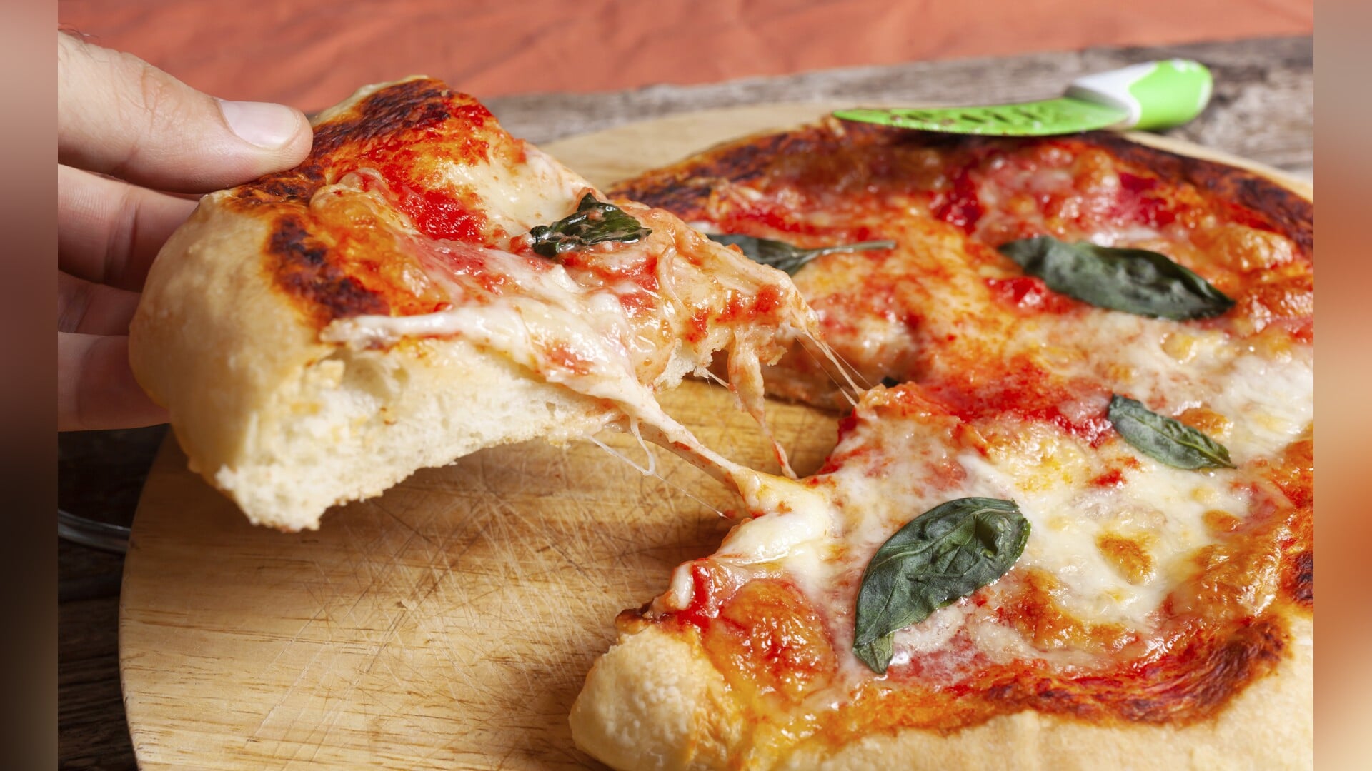 Fresh Homemade Italian Pizza Margherita with basil on rustic background.