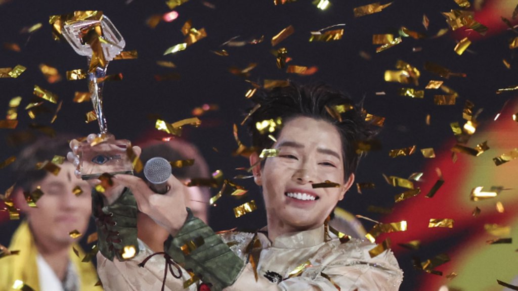 De Vietnamese artiest Duc Phuc, winnaar van het internationale songfestival Intervision, houdt zijn trofee omhoog.